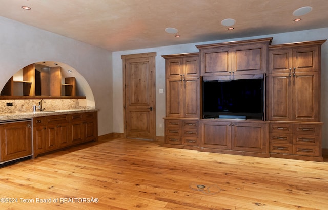 unfurnished living room featuring light wood-type flooring and sink