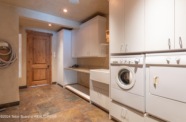 laundry room with cabinets, independent washer and dryer, and sink