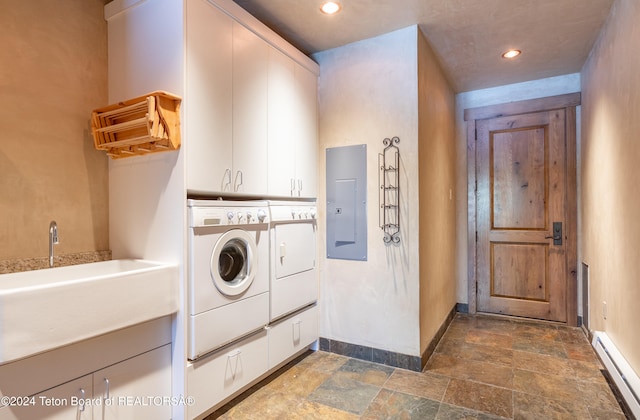 laundry room featuring sink, cabinets, baseboard heating, separate washer and dryer, and electric panel