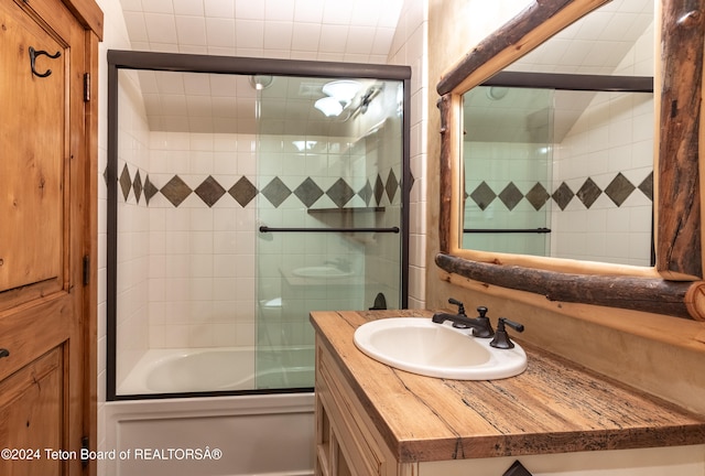 bathroom with vanity and combined bath / shower with glass door