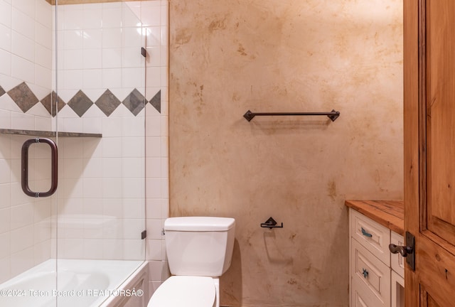 bathroom featuring combined bath / shower with glass door and toilet