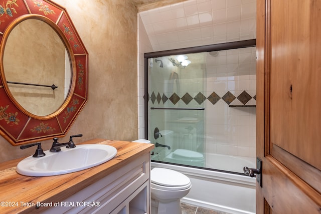 full bathroom featuring tile patterned floors, vanity, toilet, and enclosed tub / shower combo