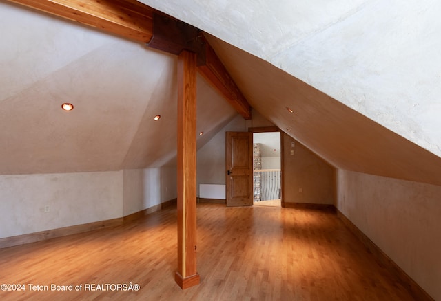 bonus room featuring vaulted ceiling with beams and light hardwood / wood-style flooring