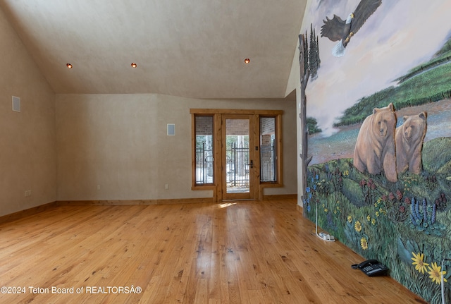 entryway with hardwood / wood-style floors and lofted ceiling