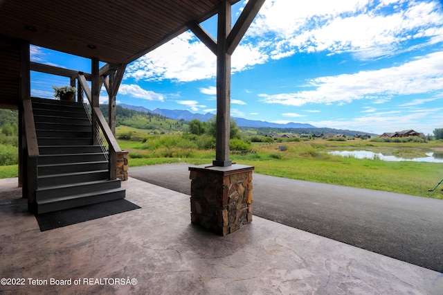 view of patio / terrace with a water and mountain view