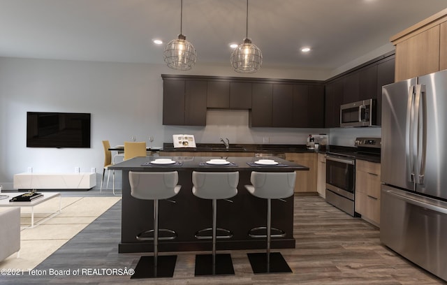 kitchen featuring appliances with stainless steel finishes, light brown cabinetry, and a kitchen island