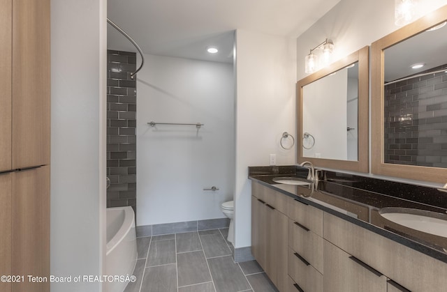 full bathroom with vanity, tiled shower / bath, tile patterned flooring, and toilet