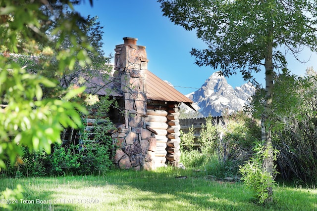 view of home's exterior featuring a mountain view and a lawn