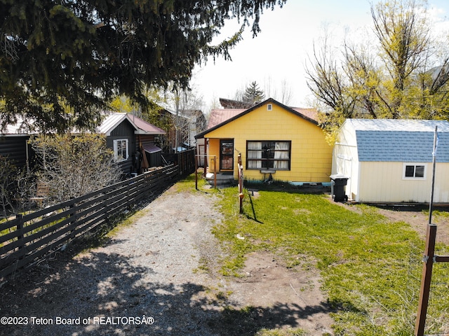 view of front of house with a shed and a front yard