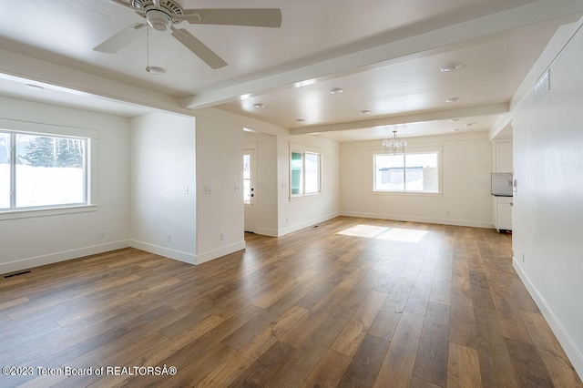 empty room with ceiling fan with notable chandelier, dark hardwood / wood-style floors, and beamed ceiling