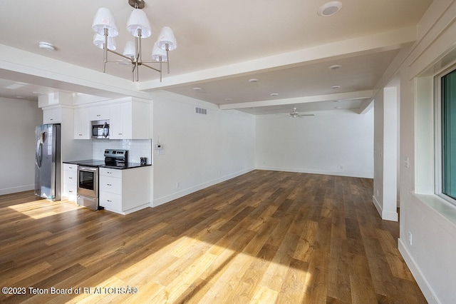 kitchen with ceiling fan with notable chandelier, tasteful backsplash, wood-type flooring, appliances with stainless steel finishes, and white cabinets