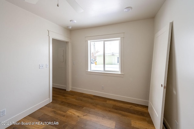 unfurnished room with ceiling fan and dark wood-type flooring