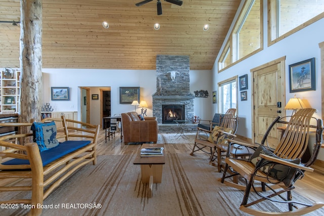 1515 Table Rock Dr, Driggs, ID 83422 - living area with high vaulted ceiling, a stone fireplace, wood ceiling, a ceiling fan, and wood finished floors