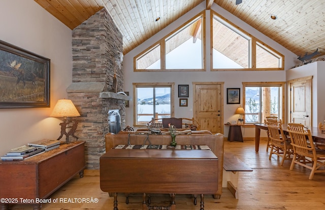 1515 Table Rock Dr, Driggs, ID 83422 - dining area featuring high vaulted ceiling, light wood-style flooring, a fireplace, plenty of natural light, and wooden ceiling