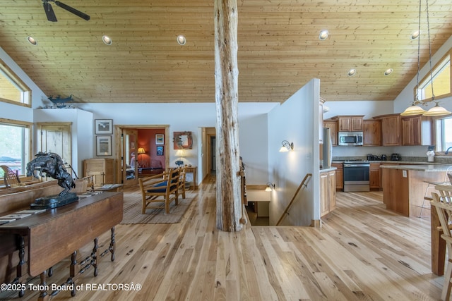 1515 Table Rock Dr, Driggs, ID 83422 - kitchen featuring appliances with stainless steel finishes, high vaulted ceiling, wood ceiling, brown cabinets, and light wood-style floors