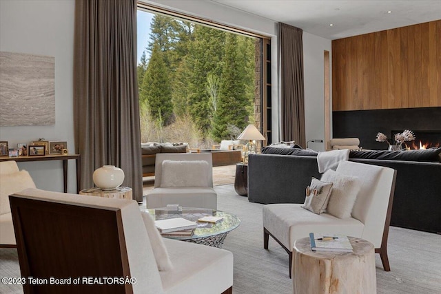 sitting room with wooden walls and light colored carpet