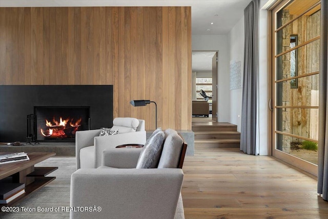 living room featuring wooden walls and light hardwood / wood-style floors