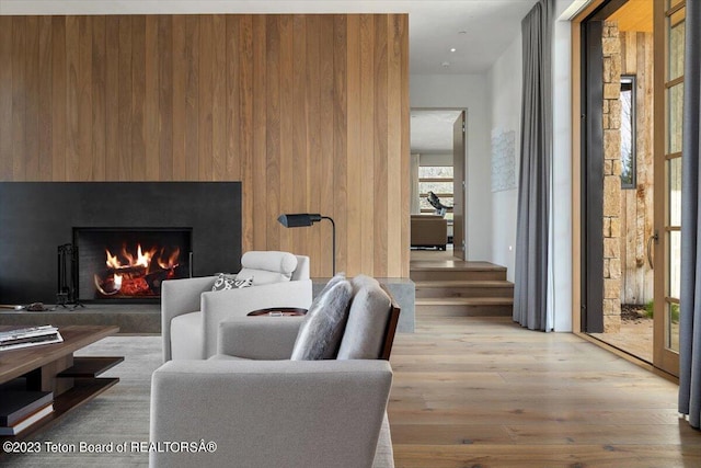 living room featuring wood walls and light hardwood / wood-style flooring