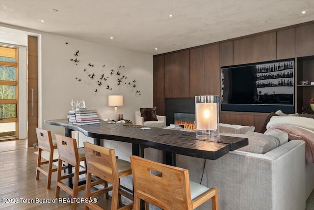 kitchen with dark brown cabinetry, a kitchen bar, and light hardwood / wood-style floors