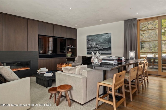 living room with a large fireplace and light hardwood / wood-style floors