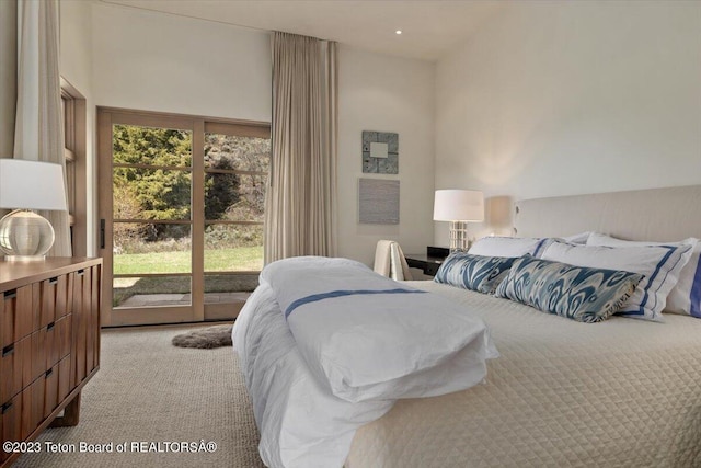 bedroom featuring a high ceiling, access to exterior, and light colored carpet