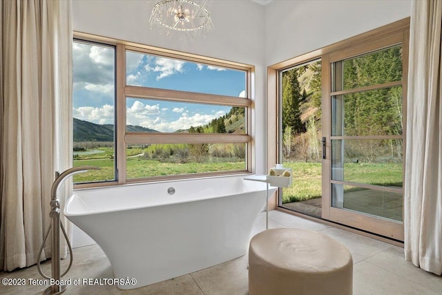 bathroom featuring tile flooring, a chandelier, and a healthy amount of sunlight