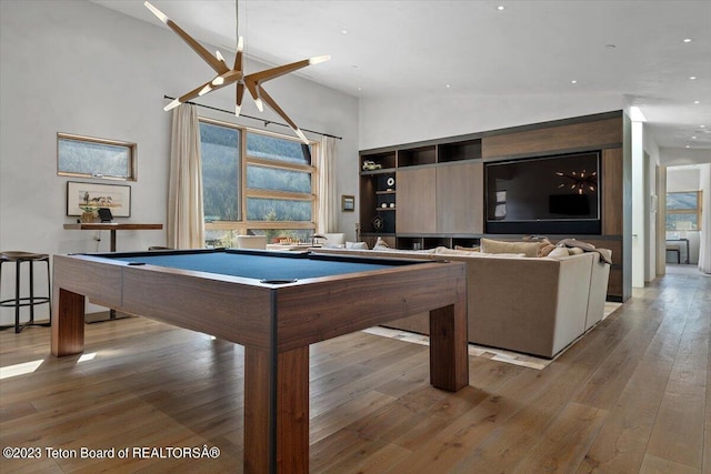 game room featuring high vaulted ceiling, hardwood / wood-style floors, and pool table