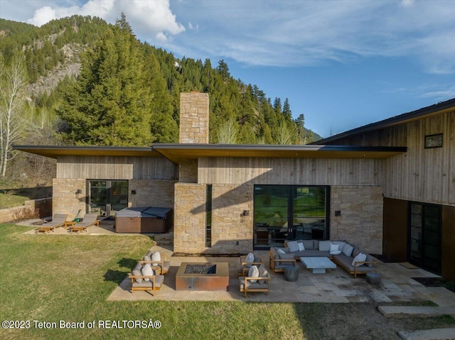 rear view of house with a lawn, a patio, and an outdoor living space