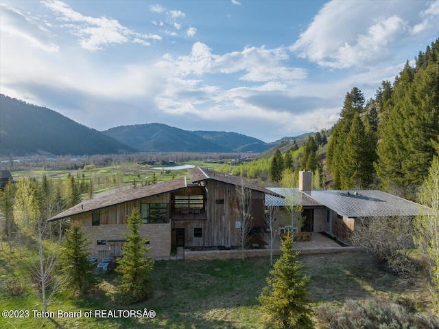 view of front of property with a mountain view and a balcony