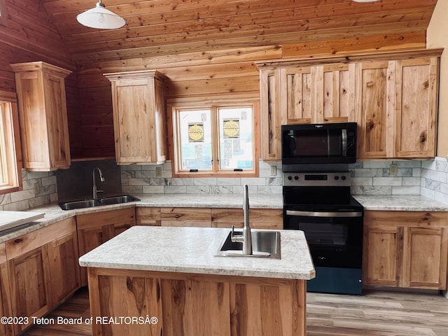 kitchen featuring wooden walls, sink, stainless steel range with electric stovetop, and vaulted ceiling