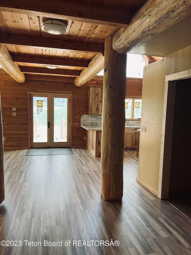 unfurnished living room featuring french doors, beam ceiling, wooden ceiling, and dark wood-type flooring