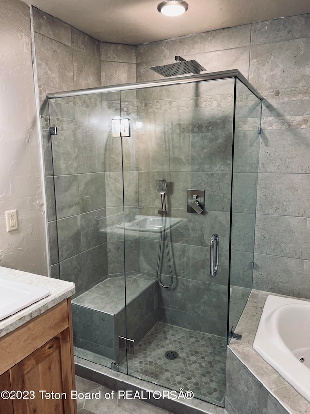 bathroom featuring shower with separate bathtub and vanity