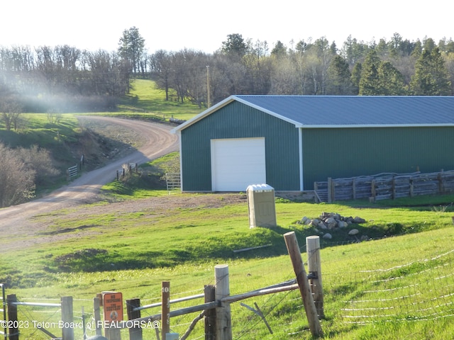 view of shed / structure with a rural view, a lawn, and a garage