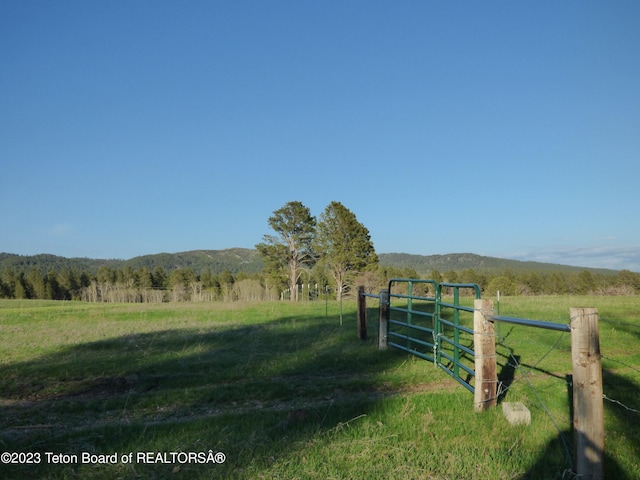 view of gate with a rural view and a yard