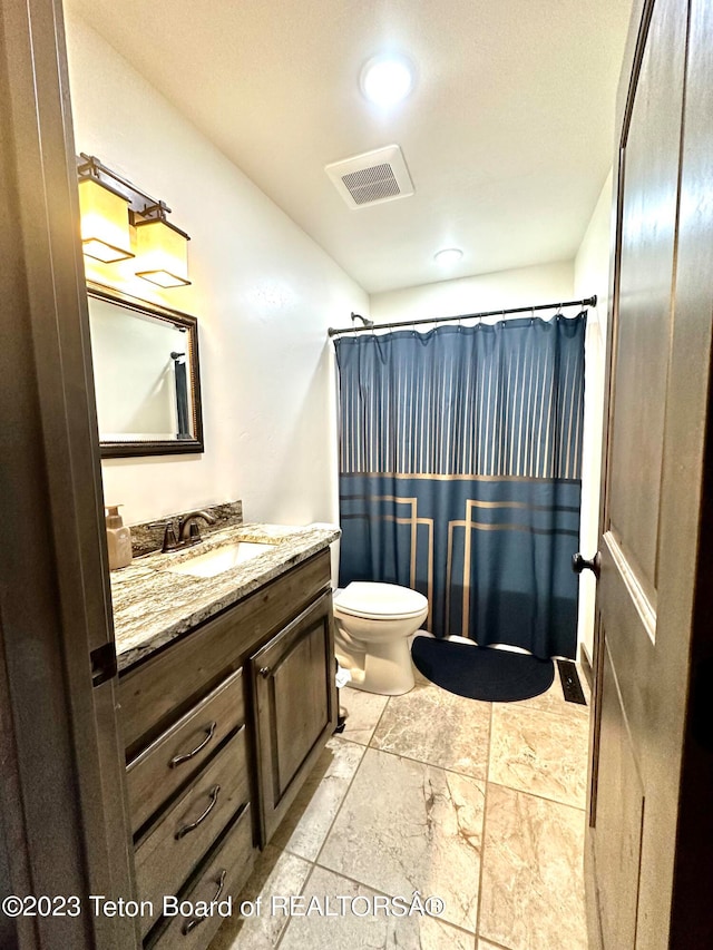 bathroom featuring toilet, tile floors, and vanity