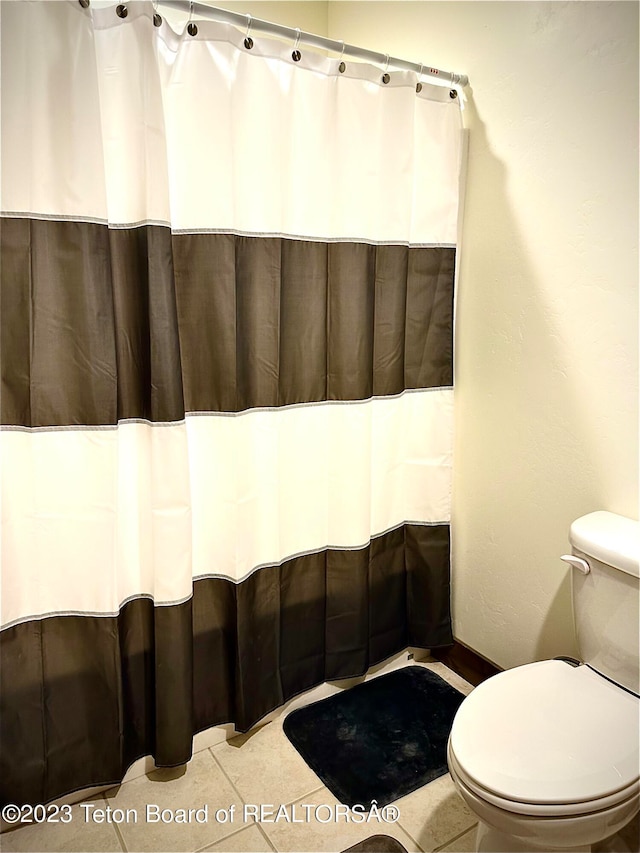 bathroom featuring toilet and tile floors