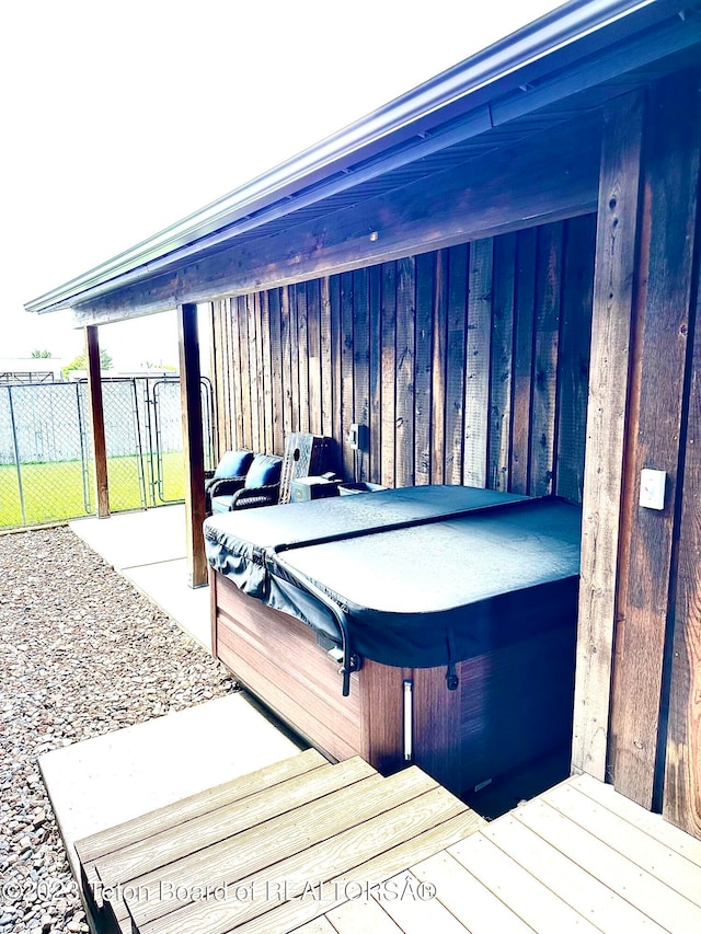 dock area featuring a hot tub and a patio