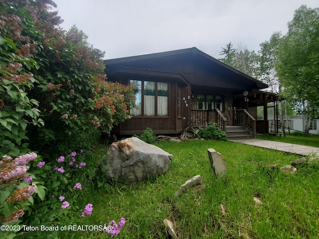 back of house featuring a lawn