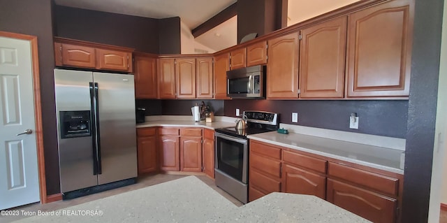 kitchen featuring light stone countertops and stainless steel appliances