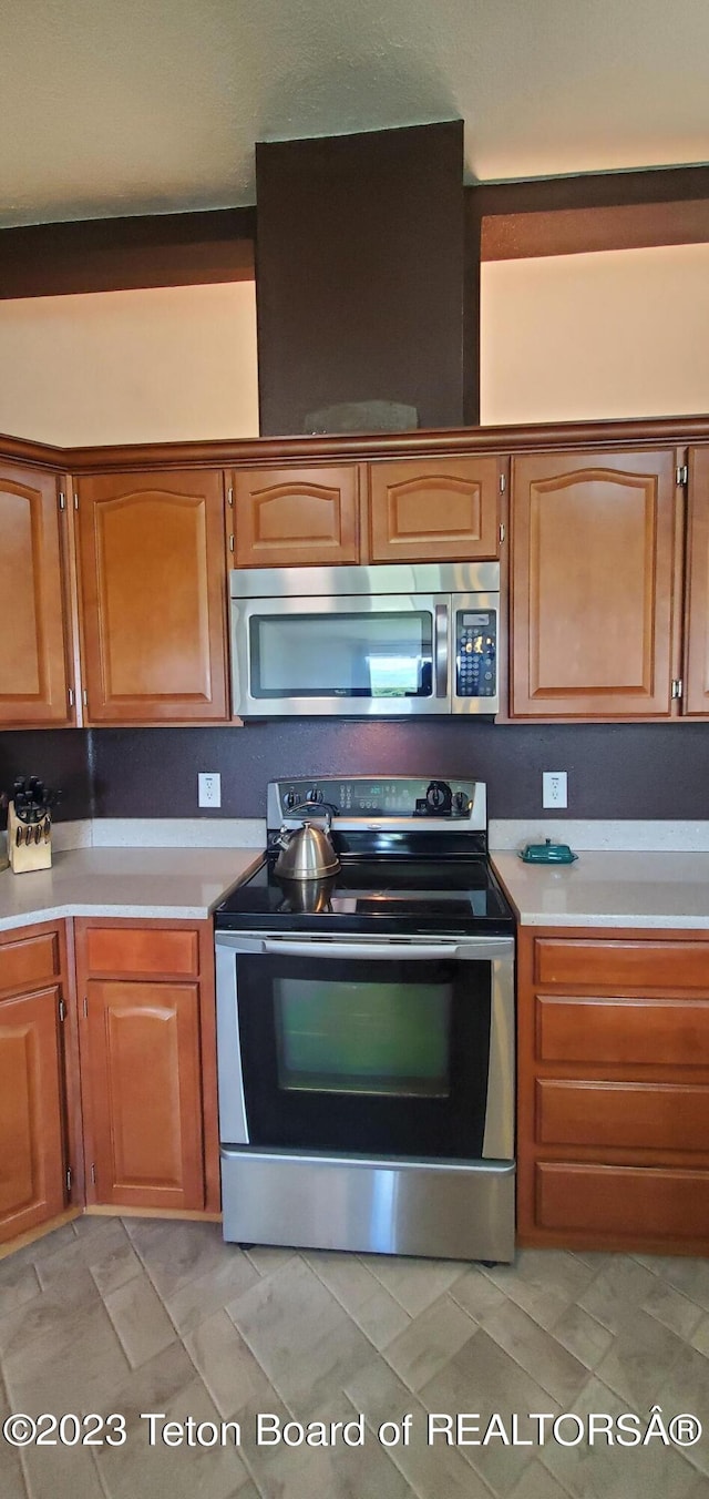 kitchen with appliances with stainless steel finishes and light tile floors