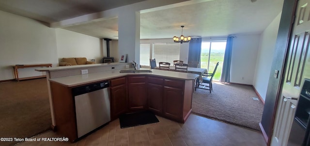 kitchen featuring hanging light fixtures, an inviting chandelier, sink, dark colored carpet, and stainless steel dishwasher