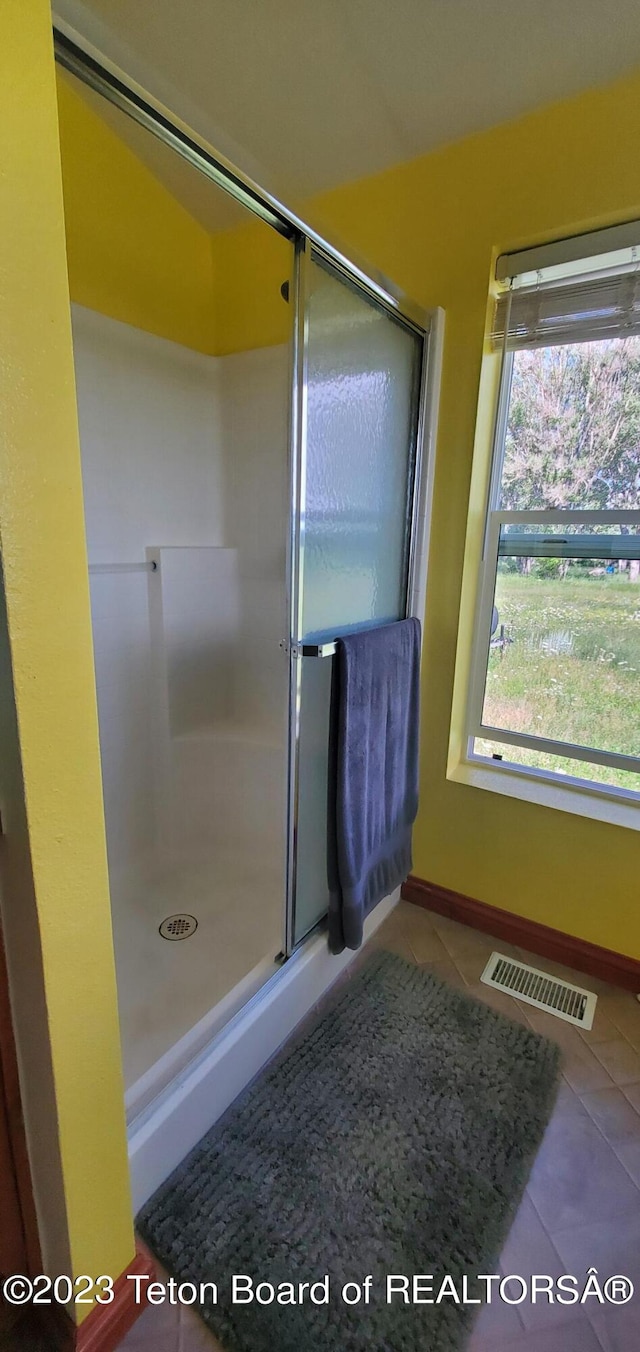 bathroom featuring walk in shower and tile floors