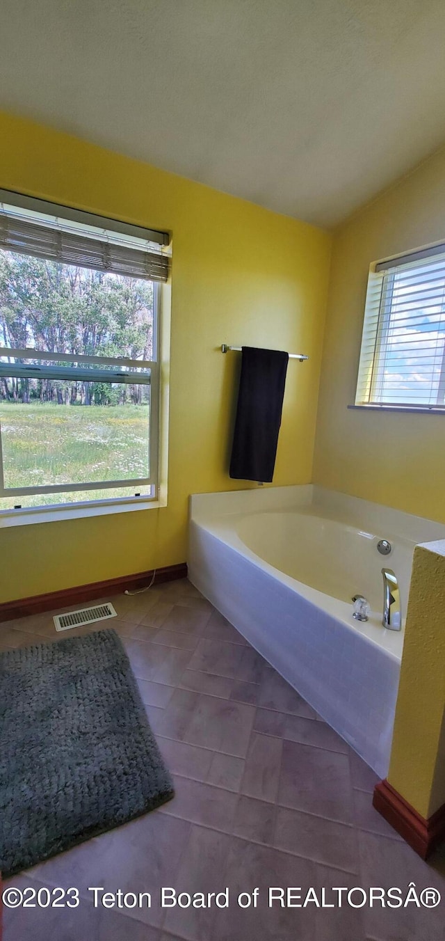 bathroom featuring tile flooring and a bath to relax in