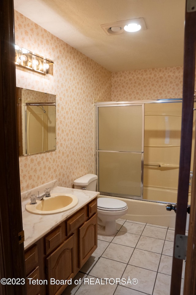 bathroom featuring toilet, vanity, and tile flooring