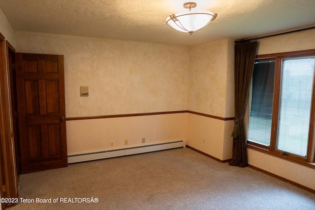 spare room featuring light carpet, plenty of natural light, a textured ceiling, and a baseboard radiator