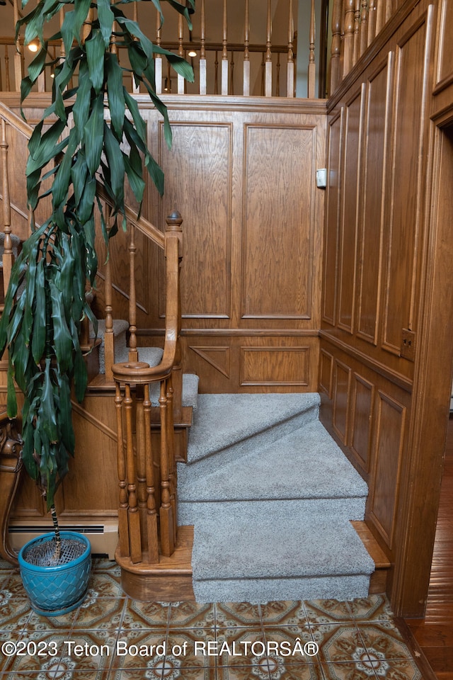 stairway with tile floors and baseboard heating