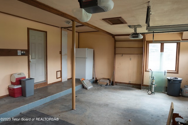 garage featuring a garage door opener and white fridge