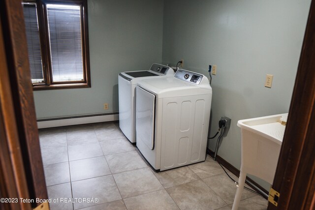 laundry area with light tile floors, washing machine and dryer, a baseboard radiator, and electric dryer hookup