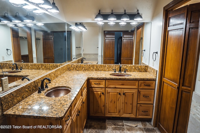 bathroom featuring dual bowl vanity, tile floors, and a bath