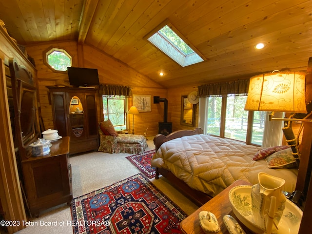 bedroom featuring multiple windows, a wood stove, wooden ceiling, carpet floors, and vaulted ceiling with skylight